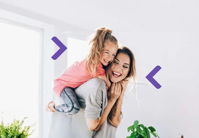 Mama z córką są w salonie, córka na plecach mamy. Razem się śmieją