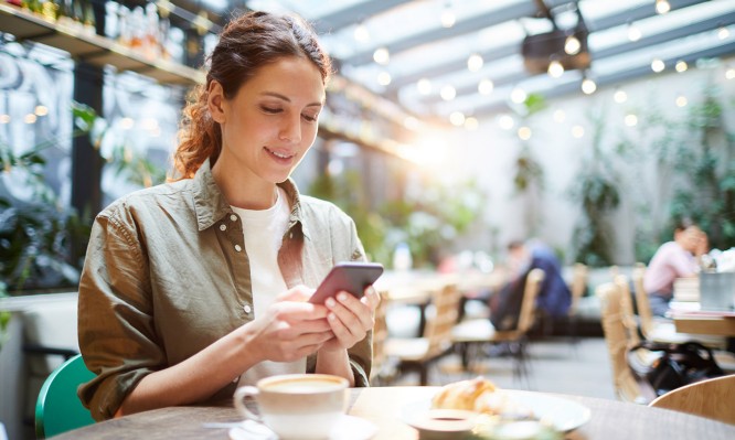 Pretty woman checking messenger in cafe