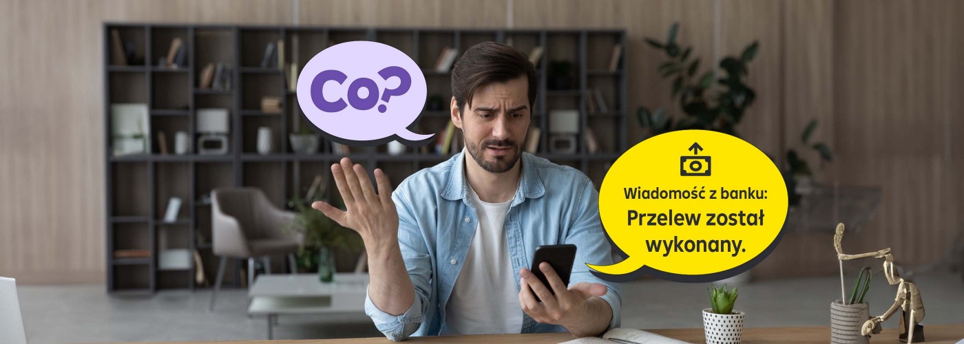 Mężczyzna w pozycji siedzącej trzymający w ręku telefon, na którym pojawiło się powiadomienie o wychodzącym przelewie bankowym. Mężczyzna jest zdziwiony tym powiadomieniem ponieważ świadomie nie zlecał żadnego przelewu