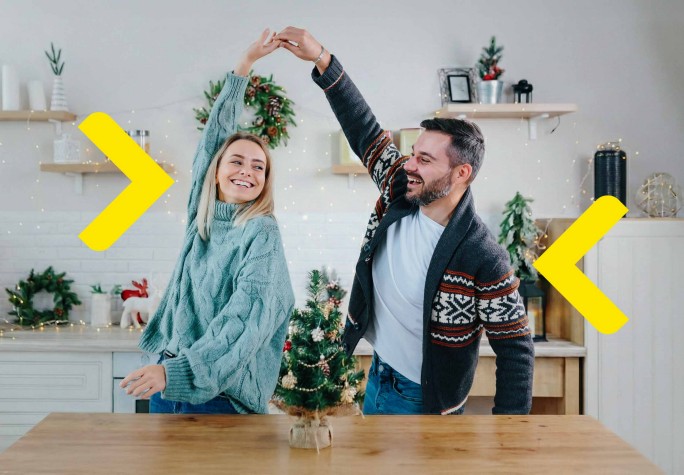 Para spędza czas w kuchni, tańcząc. Dookoła widać ozdoby świąteczne.