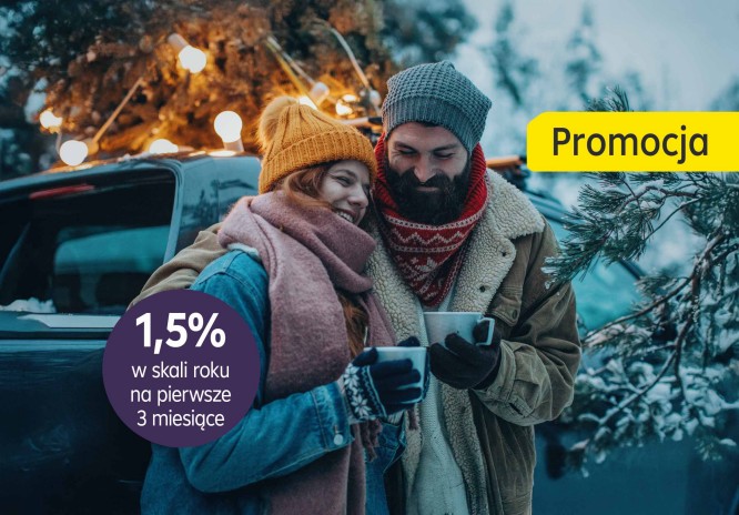 Para stoi przy samochodzie w lesie i pije ciepły napój z kubeczków. Para się przytuka. W tle widać ośniezone drzewa i światełka na gałęziach.