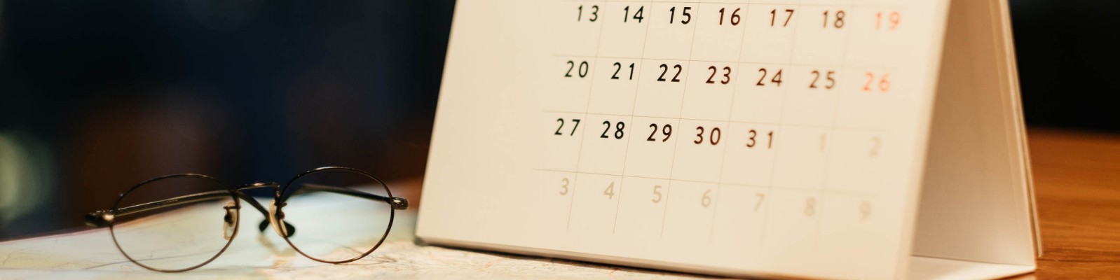 Zdjęcie przedstawia kalendarz na stojaku oraz okulary